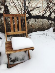 Wooden chair covered in snow